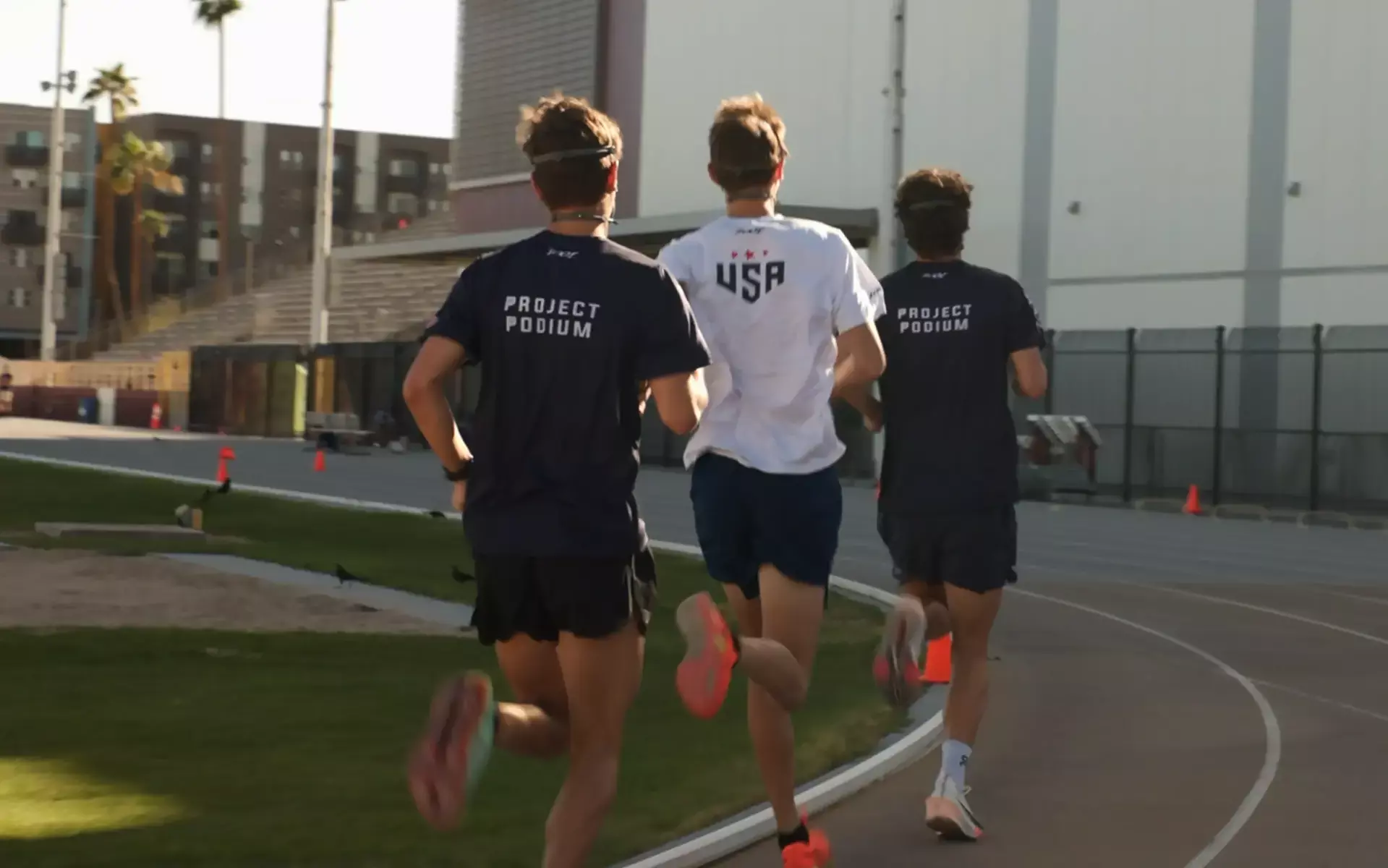 Drei USAT-Athletinnen und -Athleten mit PACER laufen tagsüber auf einer Außenbahn.